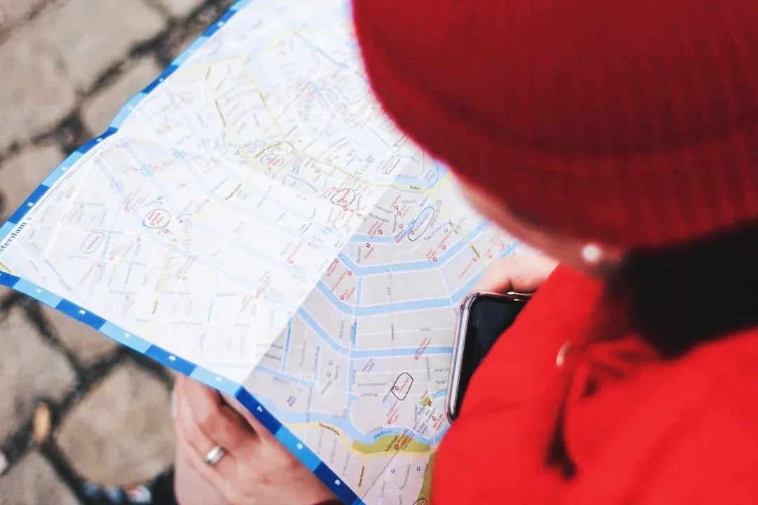 person navigating a busy city street with a map in hand